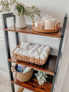 three shelves with towels and baskets on them