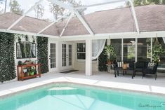 a house with a pool in the middle and lots of greenery on the walls