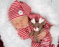 a newborn baby is wearing a red and white striped outfit with a reindeer hat on