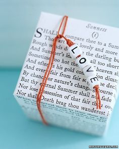 an origami book with the word love written on it is tied to a string