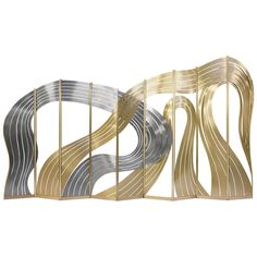 a metal sculpture with gold and silver lines on it's sides, against a white background