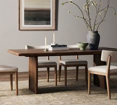 a dining room table with chairs and a vase filled with flowers on top of it