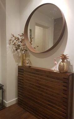 a mirror on the wall above a wooden dresser