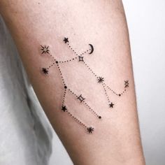 a woman's arm with stars and the moon on it, in black ink