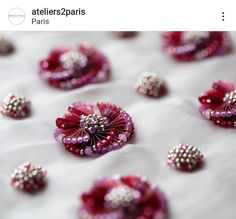 red and white beads are arranged on a tablecloth with other items in the background