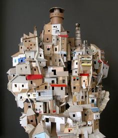 a sculpture made out of cardboard with buildings on the top and rooftops in the middle