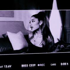 a black and white photo of a woman with long hair on the screen in her bedroom