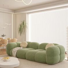 a living room filled with furniture and a large window covered in white sheers next to a dining table