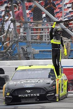 a man standing on top of a race car