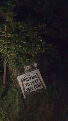 a sign that reads prepare to meet my god on the side of a road at night