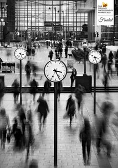 many people are walking around with clocks in the middle of their lapse photo, and there is no image here to provide a caption