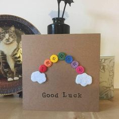 there is a card with buttons on it and a cat sitting in the back ground