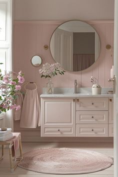 a bathroom with pink walls and flooring has a round rug on the floor next to the sink