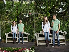 three people standing on two wooden benches in front of some trees and bushes with flowers