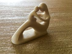 a small white sculpture sitting on top of a wooden table