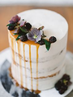 a white cake with berries and flowers on top