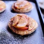 apple pies on a baking sheet with powdered sugar