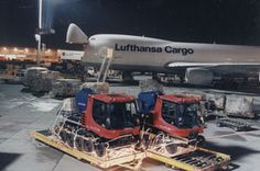 two workers are loading cargo onto an airplane