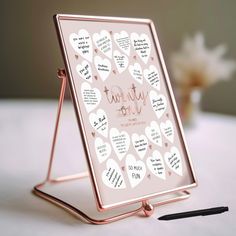 there is a pink and white heart shaped frame with writing on the side, along with a black marker