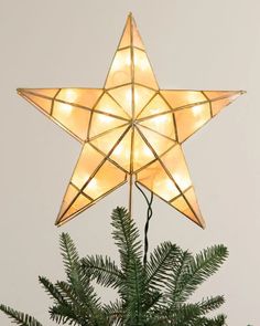 a lighted star on top of a christmas tree