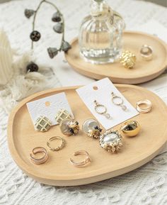 two wooden trays filled with jewelry on top of a table