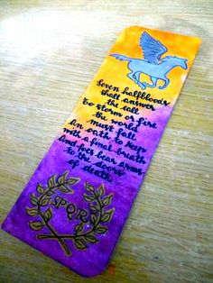 a purple and yellow bookmark with an image of a bird on it's side