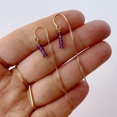 Our dainty genuine amethyst thread earrings are the perfect lightweight everyday earring. As simple as they are, the dangling purple beaded amethyst combined with a sleek box chain makes a sparkling statement. Amethyst is the February birthstone and would make a great birthstone earring gift. We offer a choice of every month's birthstone as well as other popular gemstones in the drop-down menu.  The model is wearing the amethyst February birthstone earrings in gold filled. Our dainty jewelry line is handmade from our New York City studio since 2005. Every item is handmade to order for you using only the highest quality materials and handpicked genuine gemstones.  All jewelry is beautifully wrapped in tissue and placed in a kraft box inside a logo drawstring pouch. This makes for great gift February Birthstone Jewelry, Haldi Outfit, Purple Beaded, Jewelry Minimalist, Thread Earrings, Birthstone Earrings, Earrings Purple, Earring Gift, Amethyst Jewelry