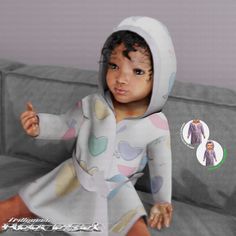 a baby doll sitting on top of a couch wearing a hoodie and pointing at the camera