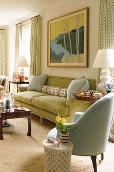 a living room filled with furniture and a painting hanging on the wall over a fire place