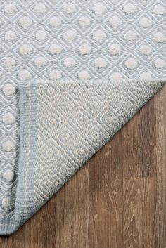 a blue and white rug on top of a wooden floor next to a wood floor