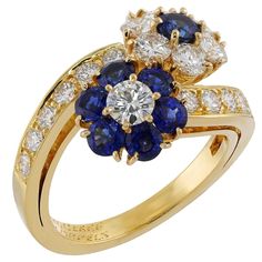 This gorgeous Van Cleef & Arpels ring from the exquisite Fleurette collection features a double flower design crafted in 18k yellow gold and set with round blue sapphires and brilliant-cut round E-F-G VVS1-VVS2 diamonds. Made in France circa 1980s. Measurements: 0.59" (15mm) width, 0.51" (13mm) length. The ring size is 5.25 - EU 50. Resizable. Sizing fees will be provided upon request. Excellent condition. Comes in original box. Please see pics for box damage. Elegant Blue Flower Ring For Formal Occasions, Elegant Multi-stone Flower Ring, Elegant Flower-shaped Multi-stone Rings, Van Cleef Arpels Ring, Gold Flower Ring, Van Cleef & Arpels, Van Cleef And Arpels, Van Cleef Arpels, Gold Flower