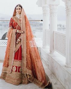 a woman in an orange and red bridal outfit