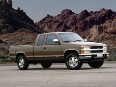 a brown truck parked in front of mountains