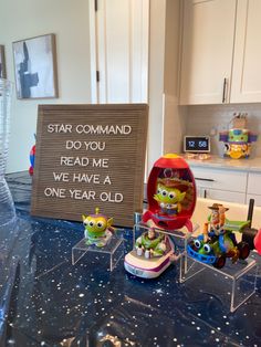 some toy figurines sitting on top of a table with a sign that says star command do you read me we have a one year old