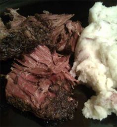 some meat and mashed potatoes on a black plate