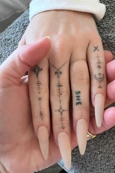 two people with matching tattoos on their fingers