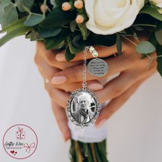 the bride is holding her bouquet with an engraved keychain on it's wrist