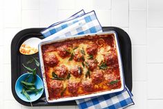 a casserole dish with meatballs and spinach