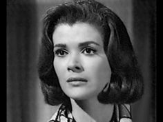 an old black and white photo of a woman with short hair wearing a plaid shirt