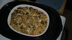 a casserole dish sitting on top of a stove in a black and white pan