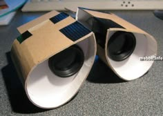 two speakers made out of cardboard sitting on top of a desk