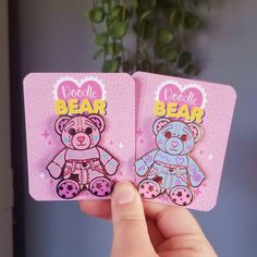 someone holding up two bear magnets in their hand