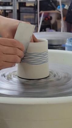 a person is working on something in a pottery wheel with their hand holding the bowl