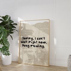 an open book sitting on top of a wooden table next to a plant