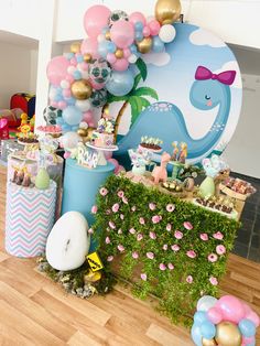 a table with balloons, cake and other items for a baby's first birthday