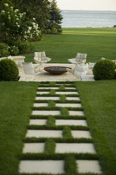 an outdoor seating area with grass and stepping stones