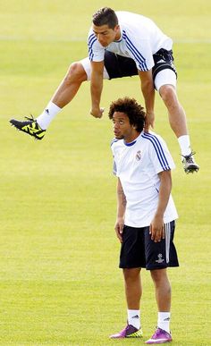 two soccer players are doing tricks on the field