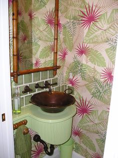 a green sink sitting under a mirror next to a wall mounted faucet in a bathroom