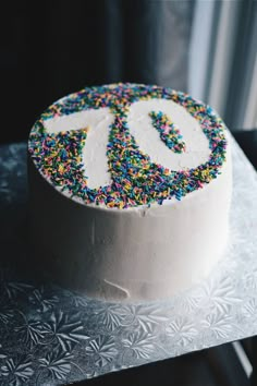 a white cake with sprinkles and the number 90 on it