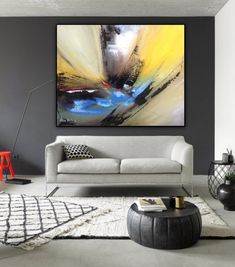 a modern living room with grey walls and white rugs, artwork on the wall